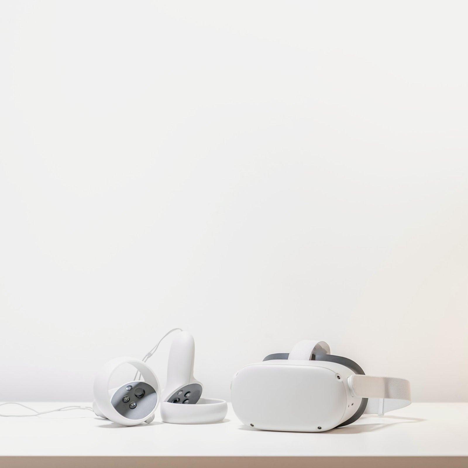 White standalone VR headset and two ring controllers on a white desk
